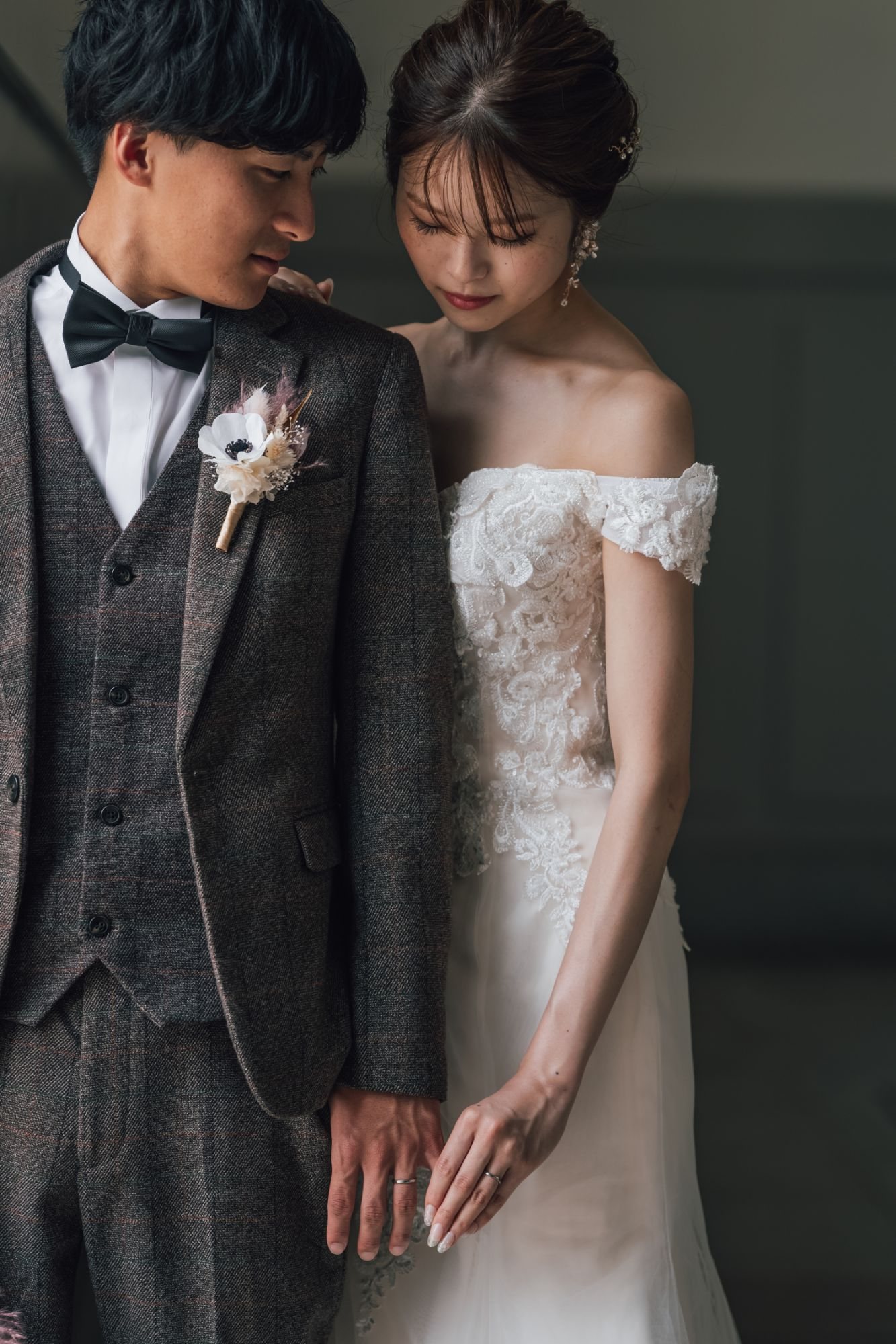 寄り添い、足元を見つめる新郎新婦