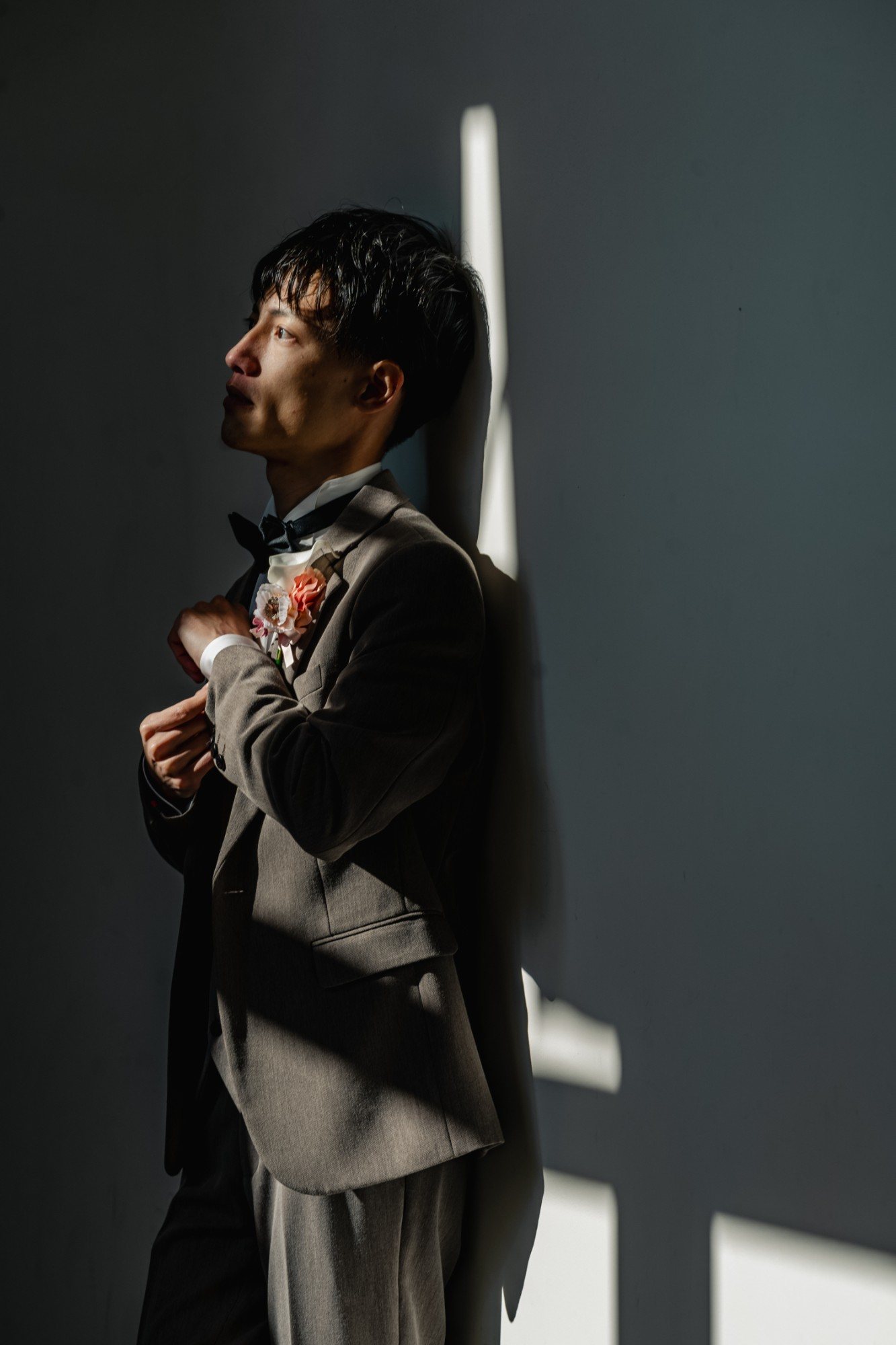 光と影の中で身支度を整える新郎